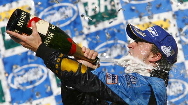 A photo of Fernando Alonso spraying Champagne on the podium. 